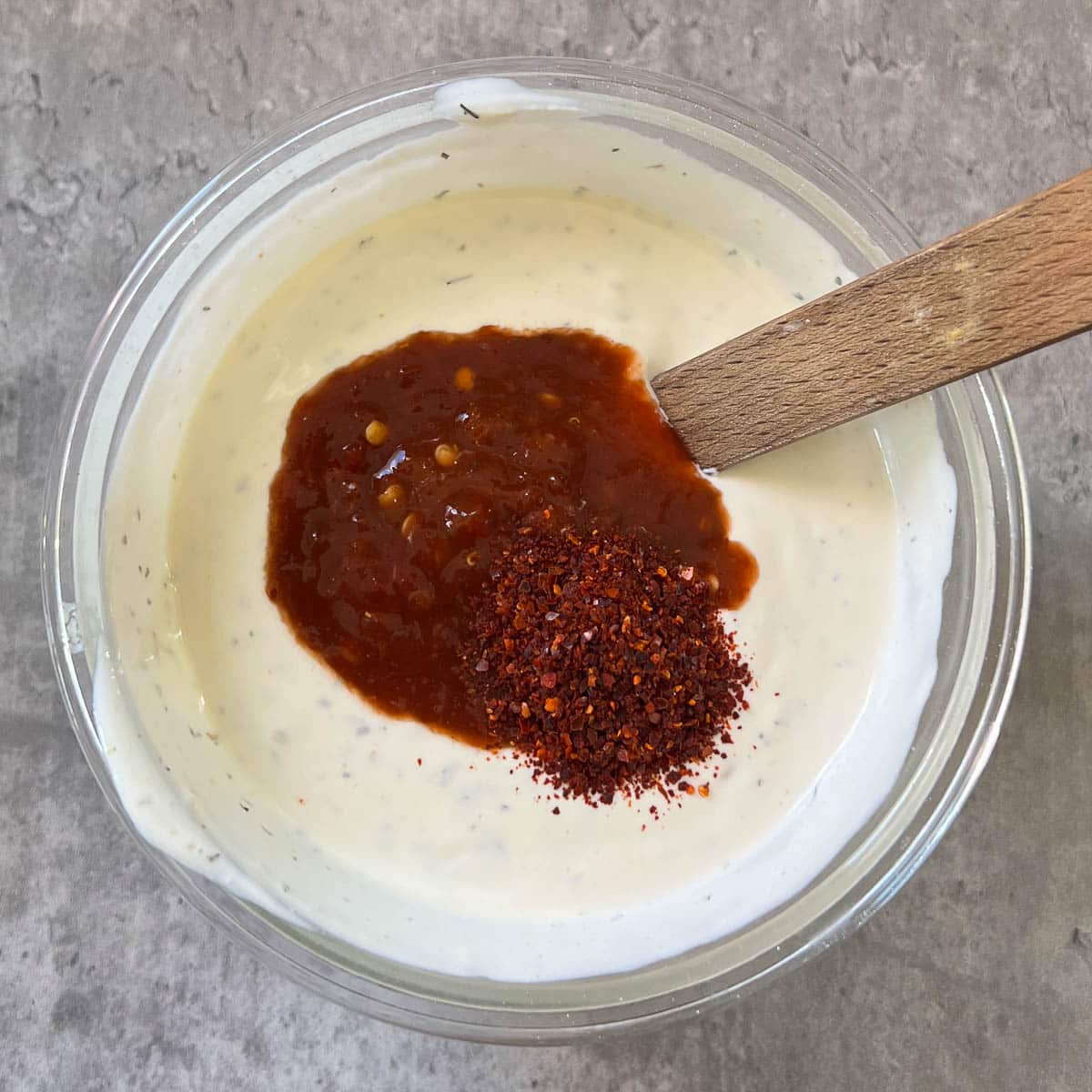 ranch dip with hot sauce and chili powder on top.