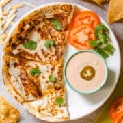 copycat taco bell quesadilla sauce in ramekin beside quesadilla and veggies.
