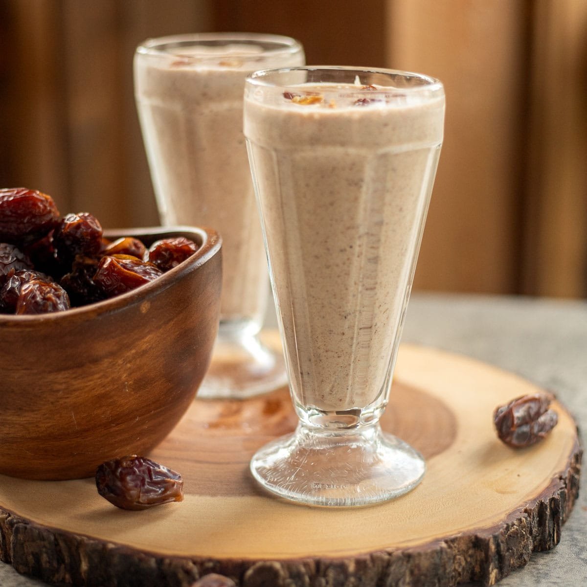 2 date shakes with dates in a bowl next to them.