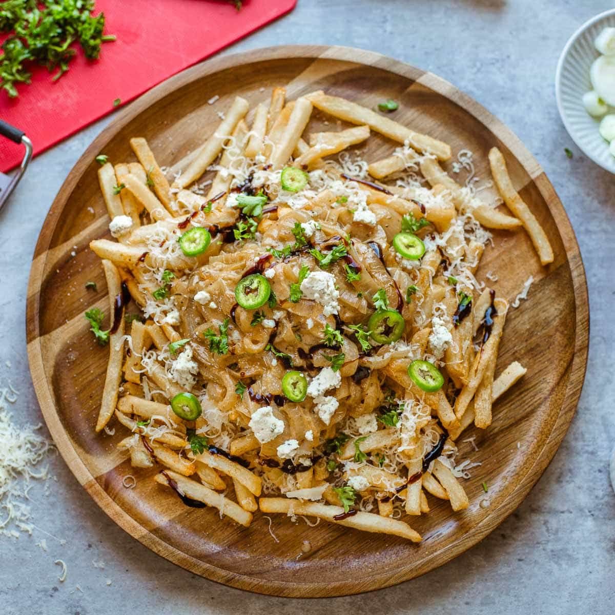 french onion fries on wooden plate.