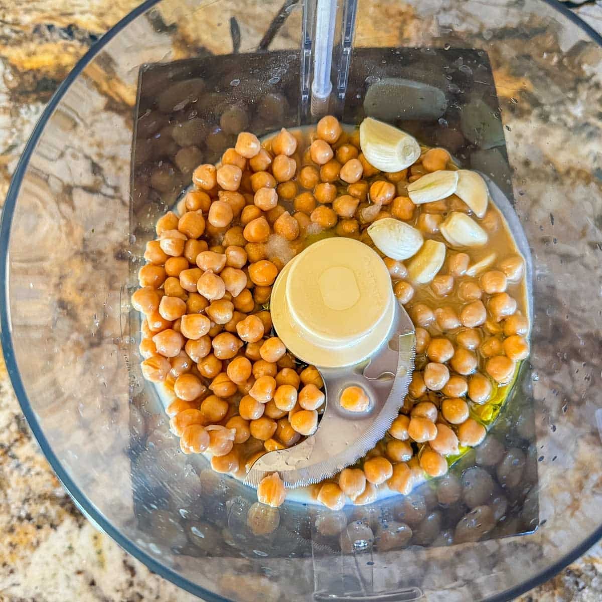 chickpeas, garlic, and other hummus ingredients in a food processor. 