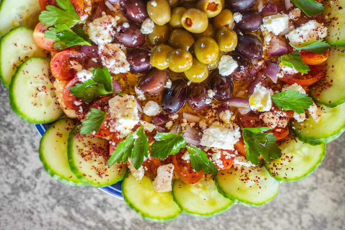 hummus topped with veggies, olives, feta cheese and more!