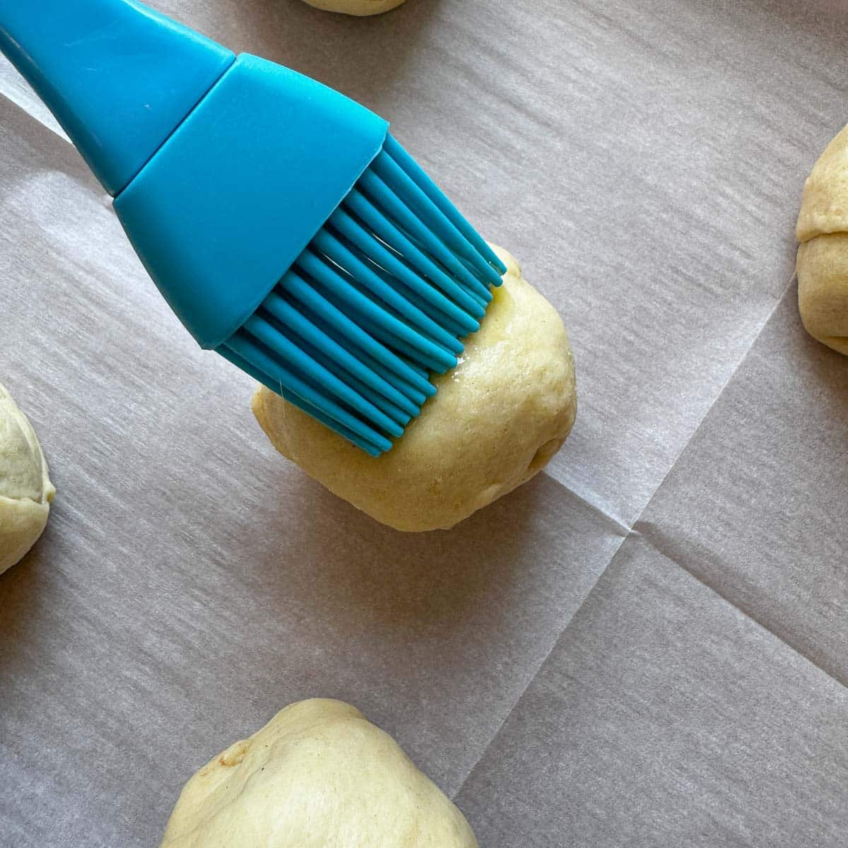 brushing unbaked resurrection rolls with butter. 