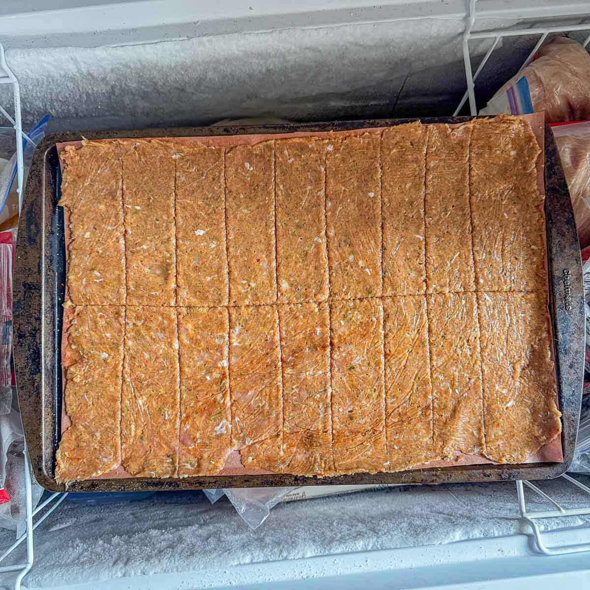 gyro chicken meat on a pan, in a freezer.