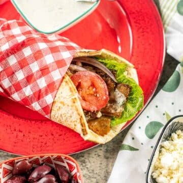 chicken gyro wrap on a red plate.