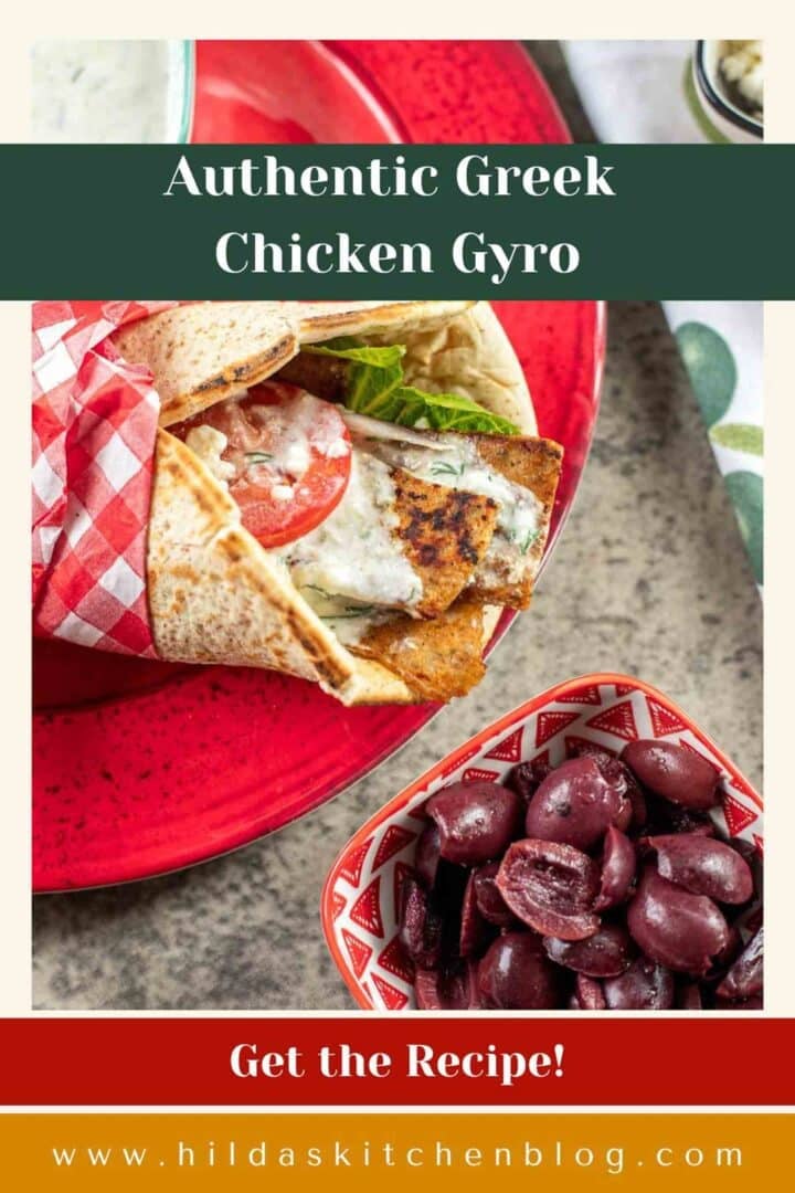 greek gyro pita on a red plate with a bowl of black olives.