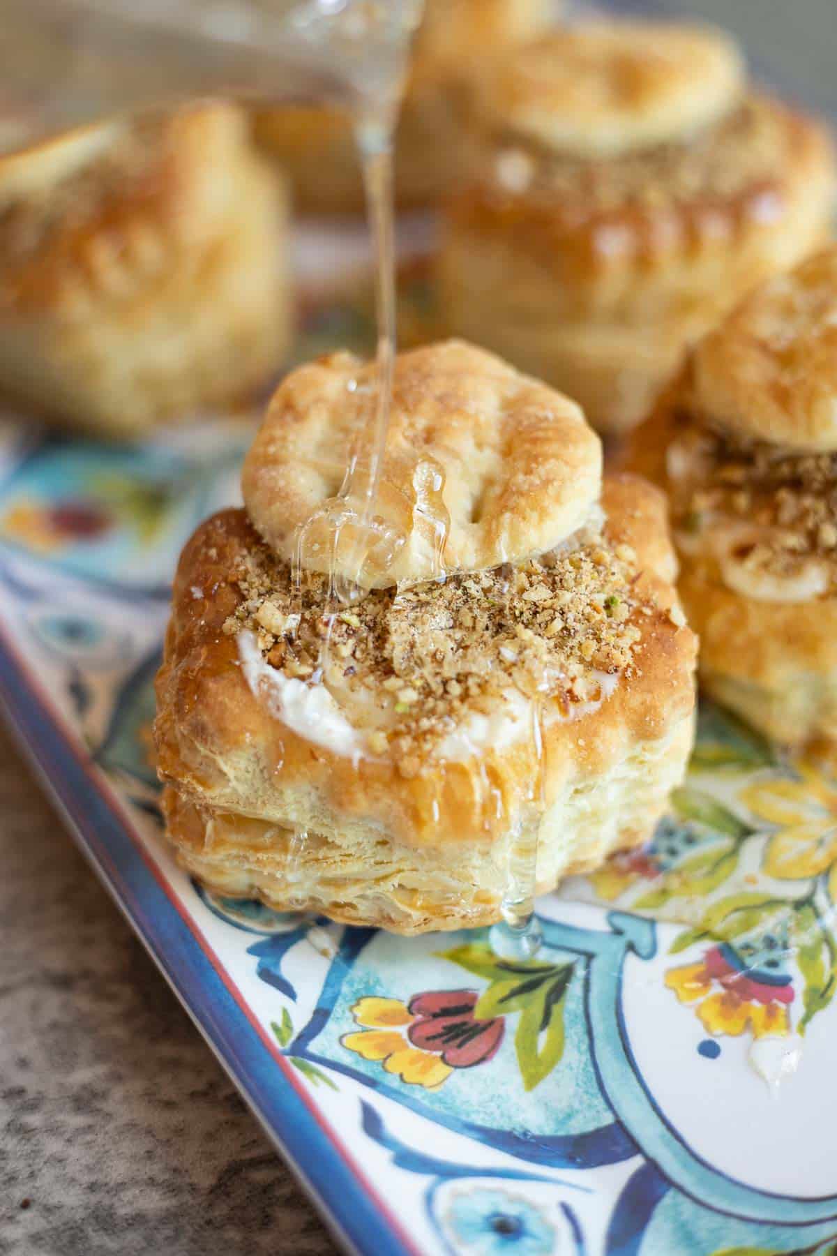 puff pastry baklava cheesecake being frizzled with syrup.