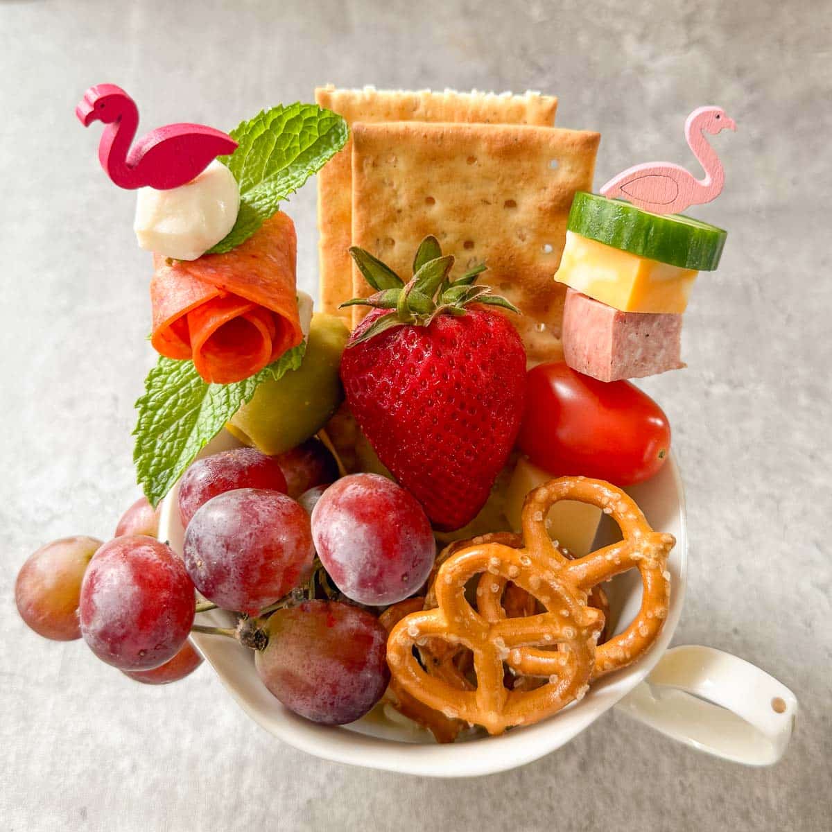 finished charcuterie cup full of fruit, cheese, meats, crackers, etc.