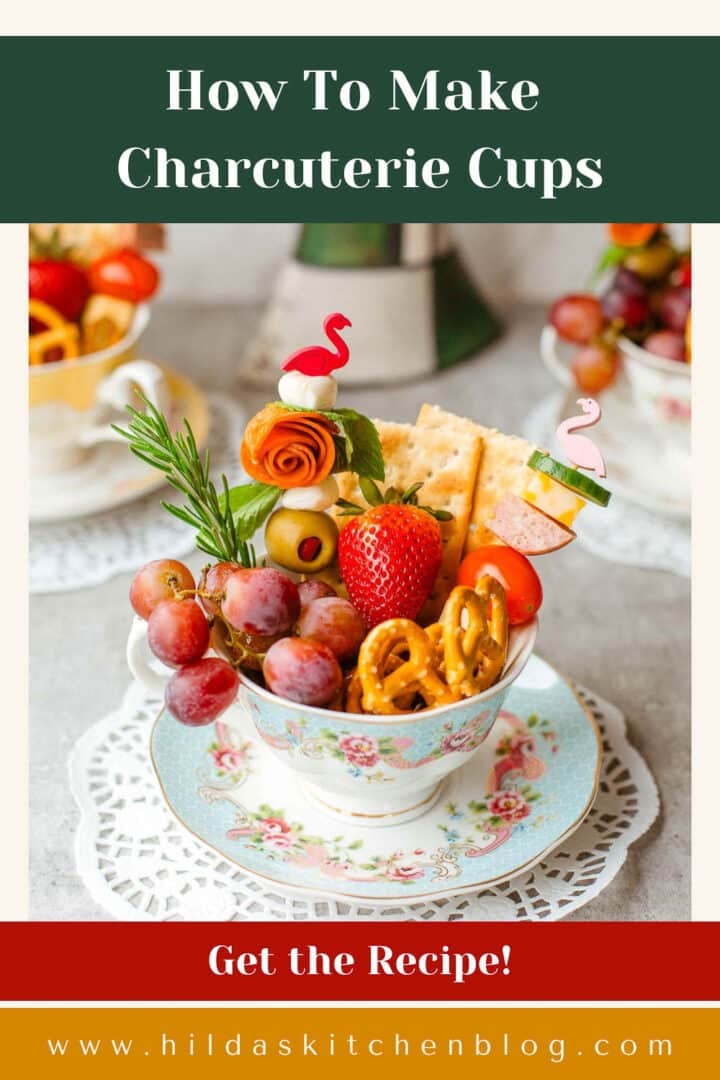 charcuterie cup full of fruits, cheese, meats. pretzels, etc. and more cups in background.