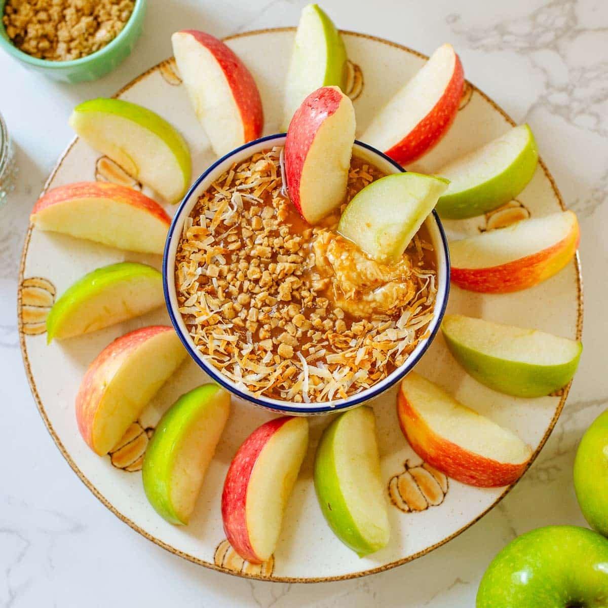 cream cheese caramel apple dip surrounded by apple slices.