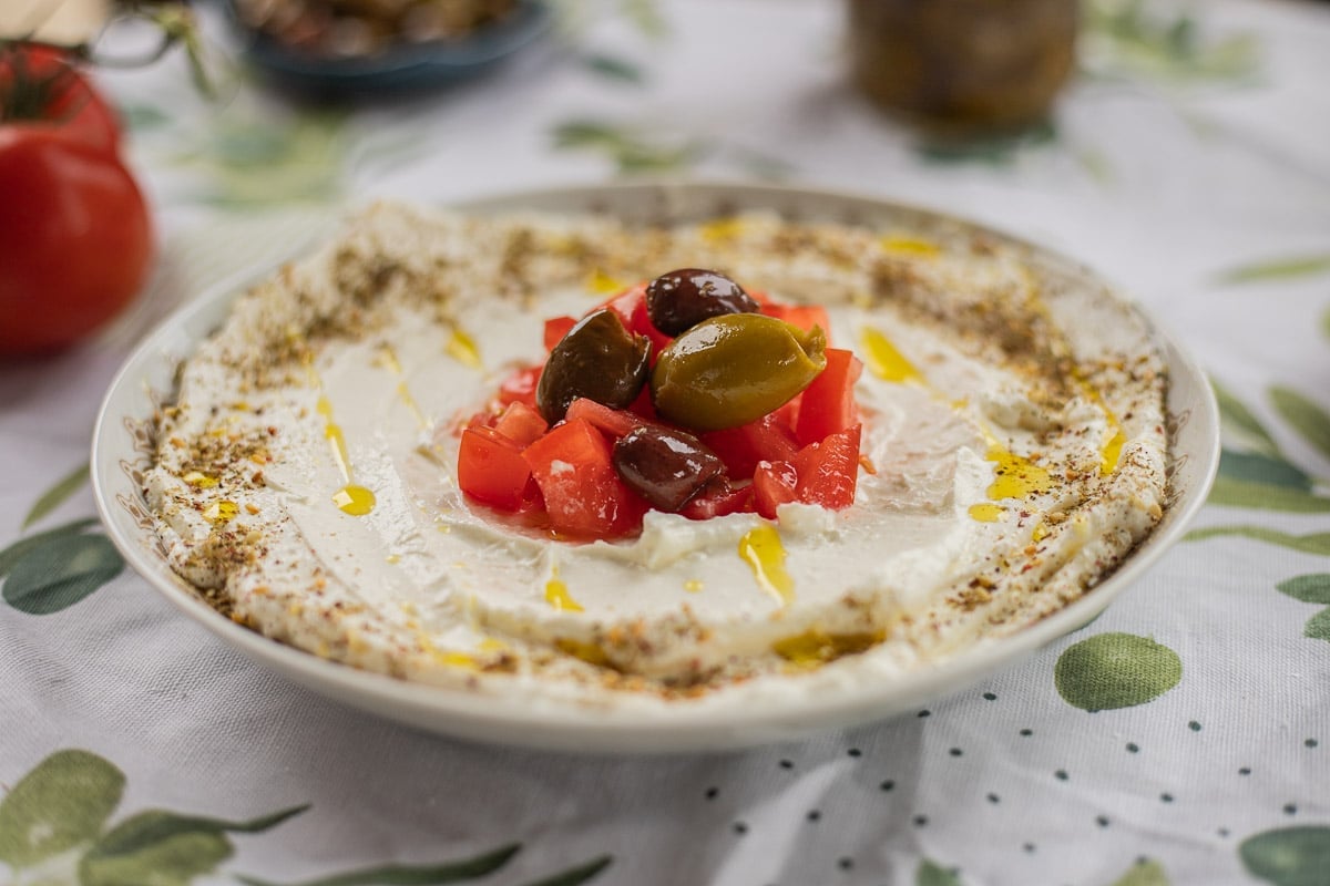 labneh topped with chopped tomatoes and olives. 