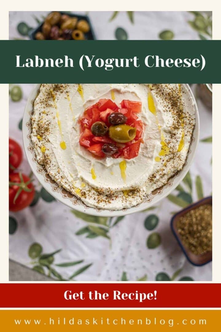 labneh in a plate topped with tomatoes and olives.