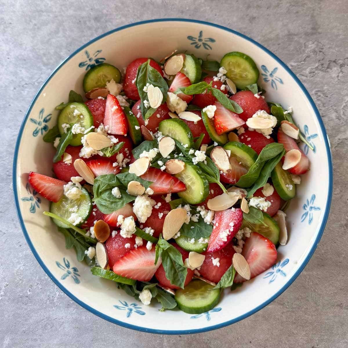cheese, herbs, strawberries, and nuts added to the salad.