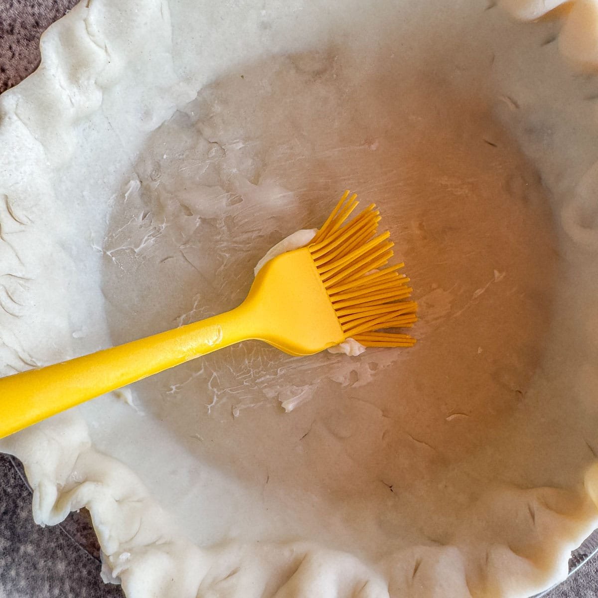 brushing pie dough with butter. 