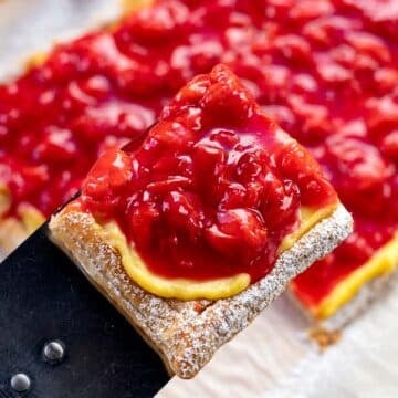 cherry tart being served by a spatula.