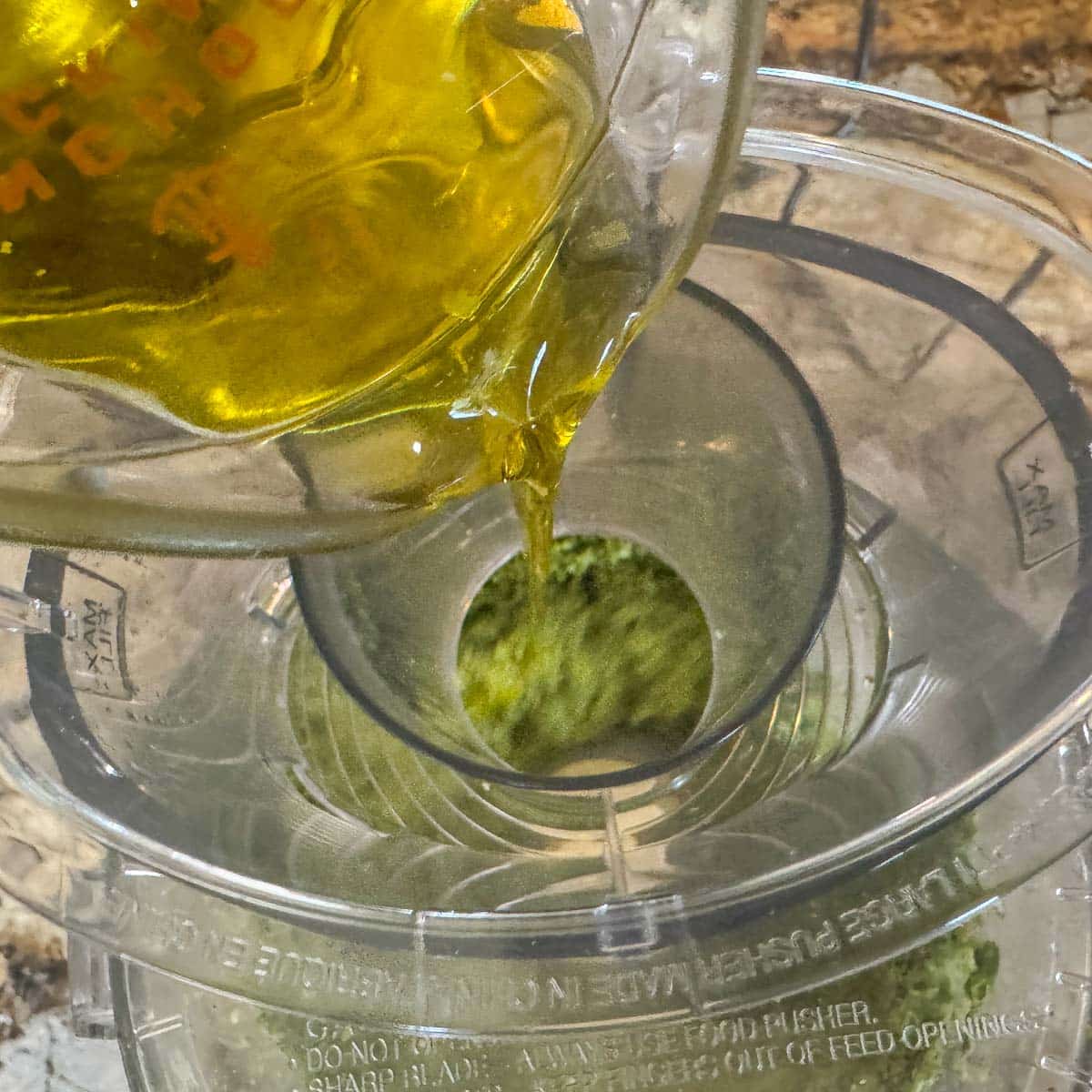 pouring oil into food processor. 