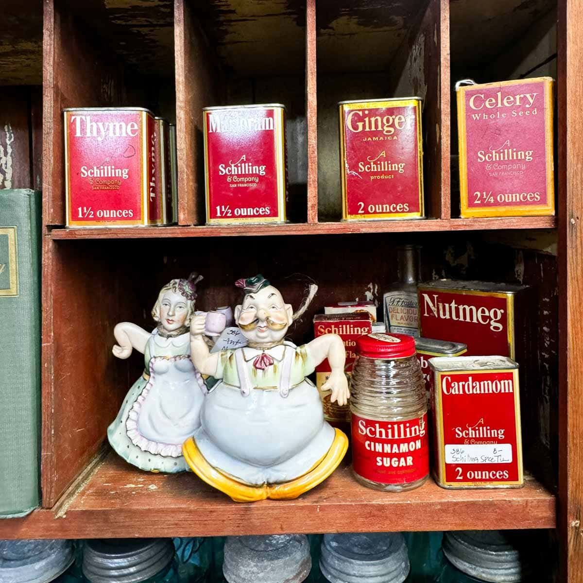 old tins on a shelf with figurines.