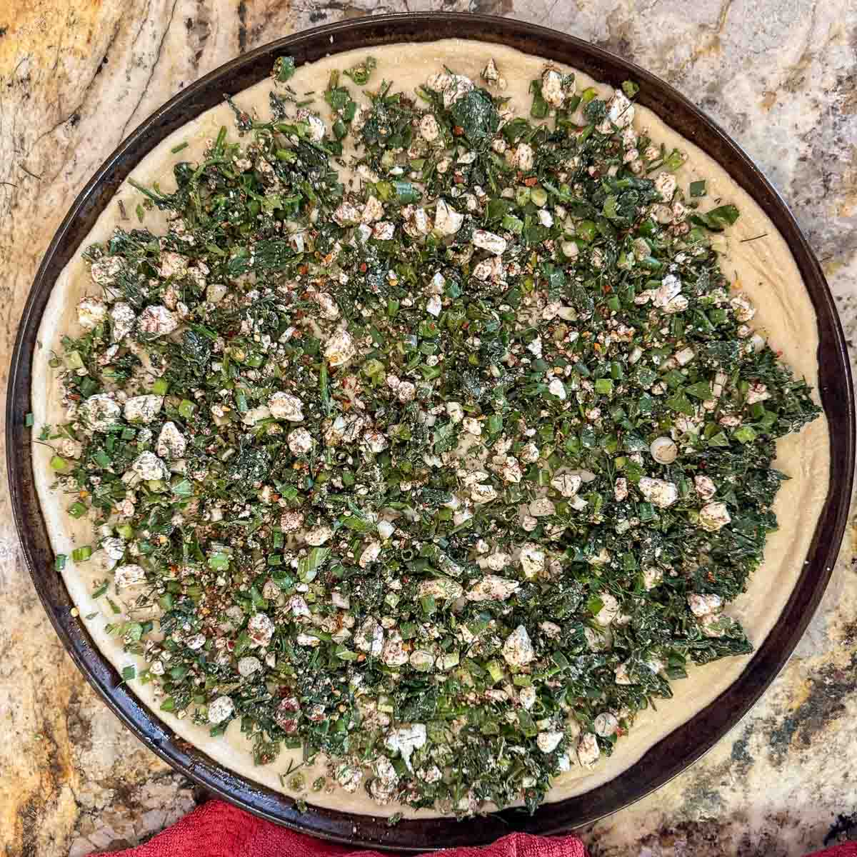 unbaked spinach and feta pizza.