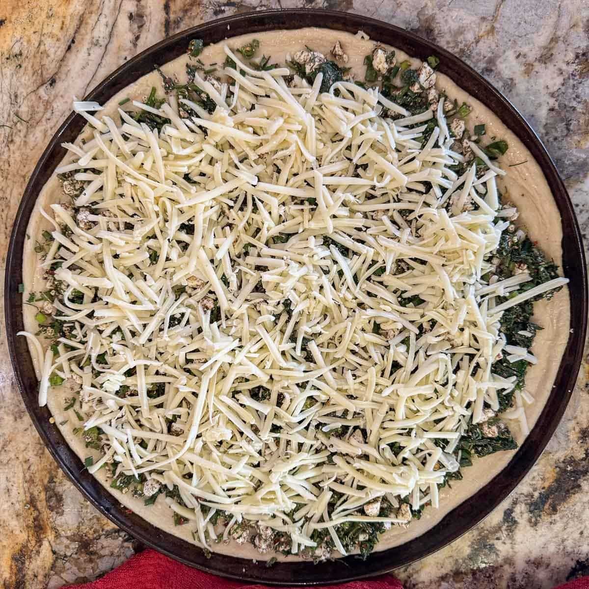 unbaked spinach and feta pizza.