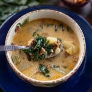 swiss chard soup in a bowl on top of a blue plate.
