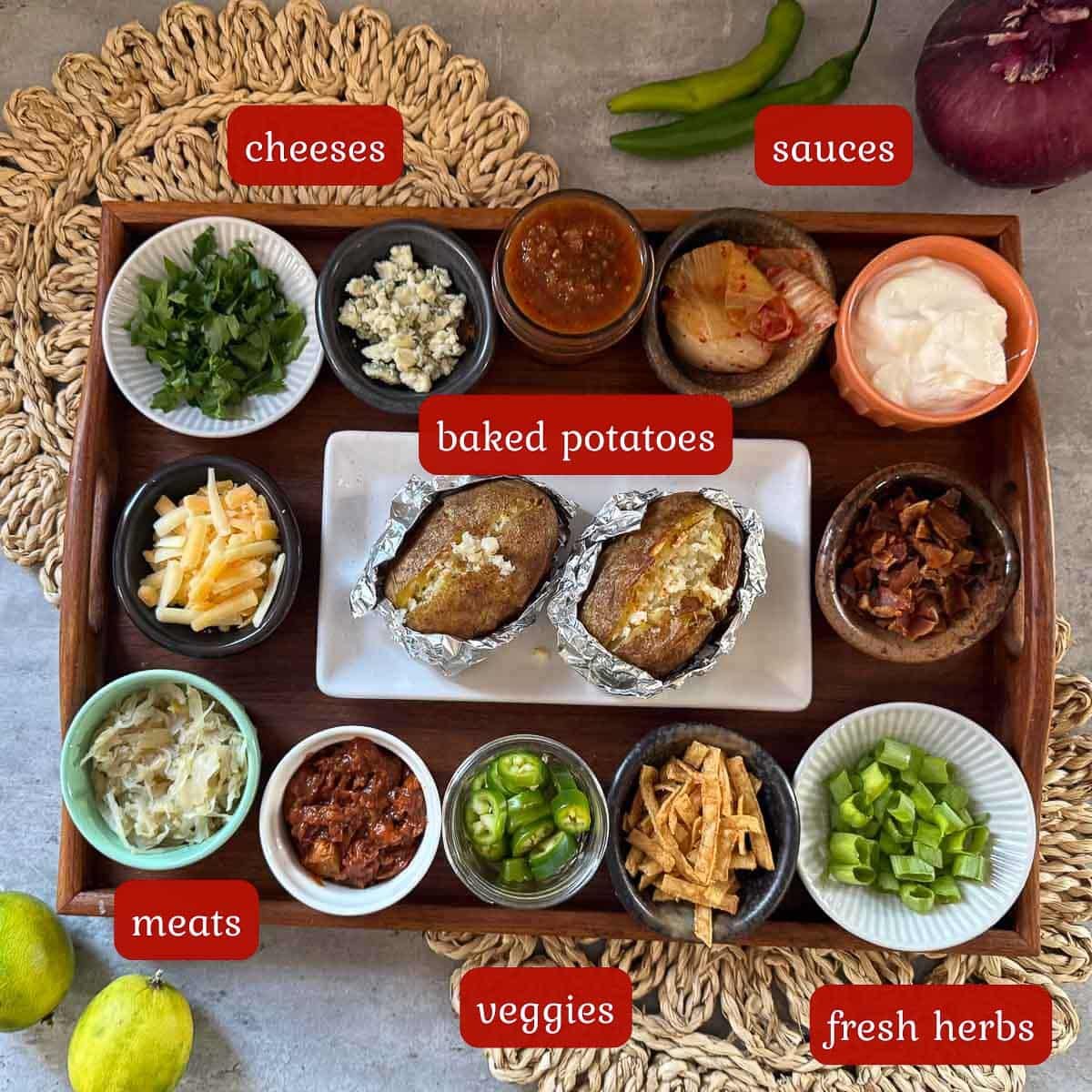 ingredient photo of various baked potato bar toppings (cheese, meat, veggies, etc.) and potatoes.
