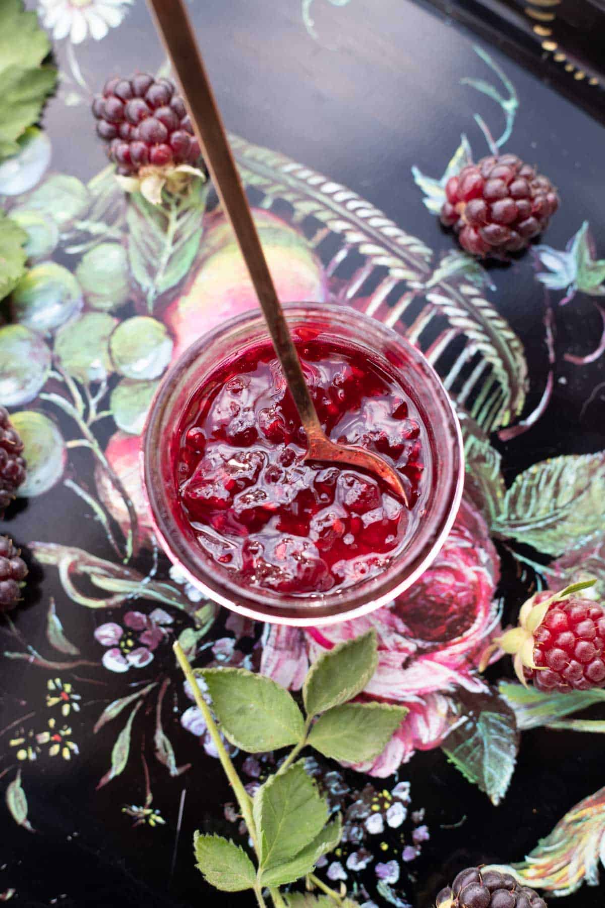 a jar of boysenberry jam with a spoon sticking out of it.