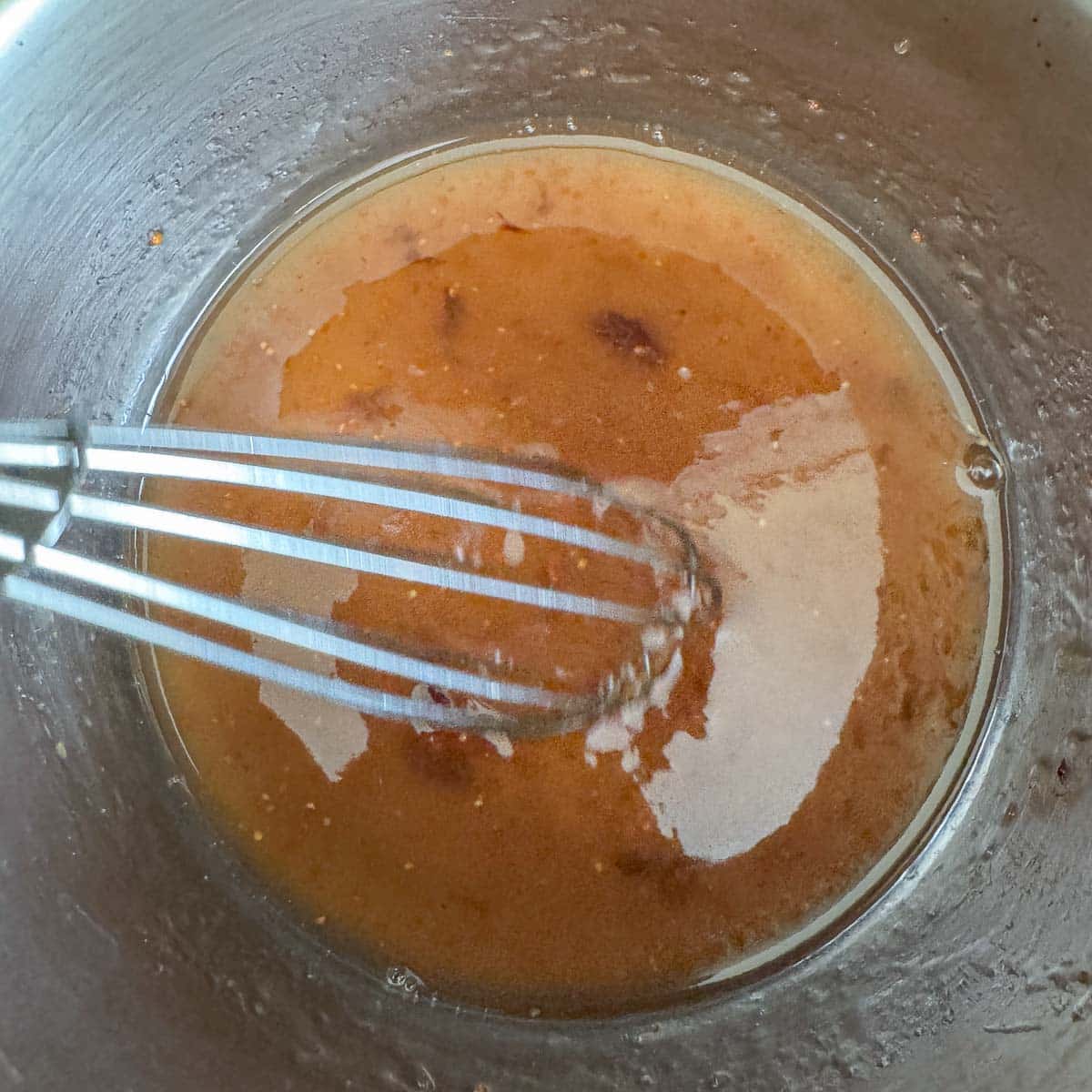 whisking fig glaze in a bowl. 