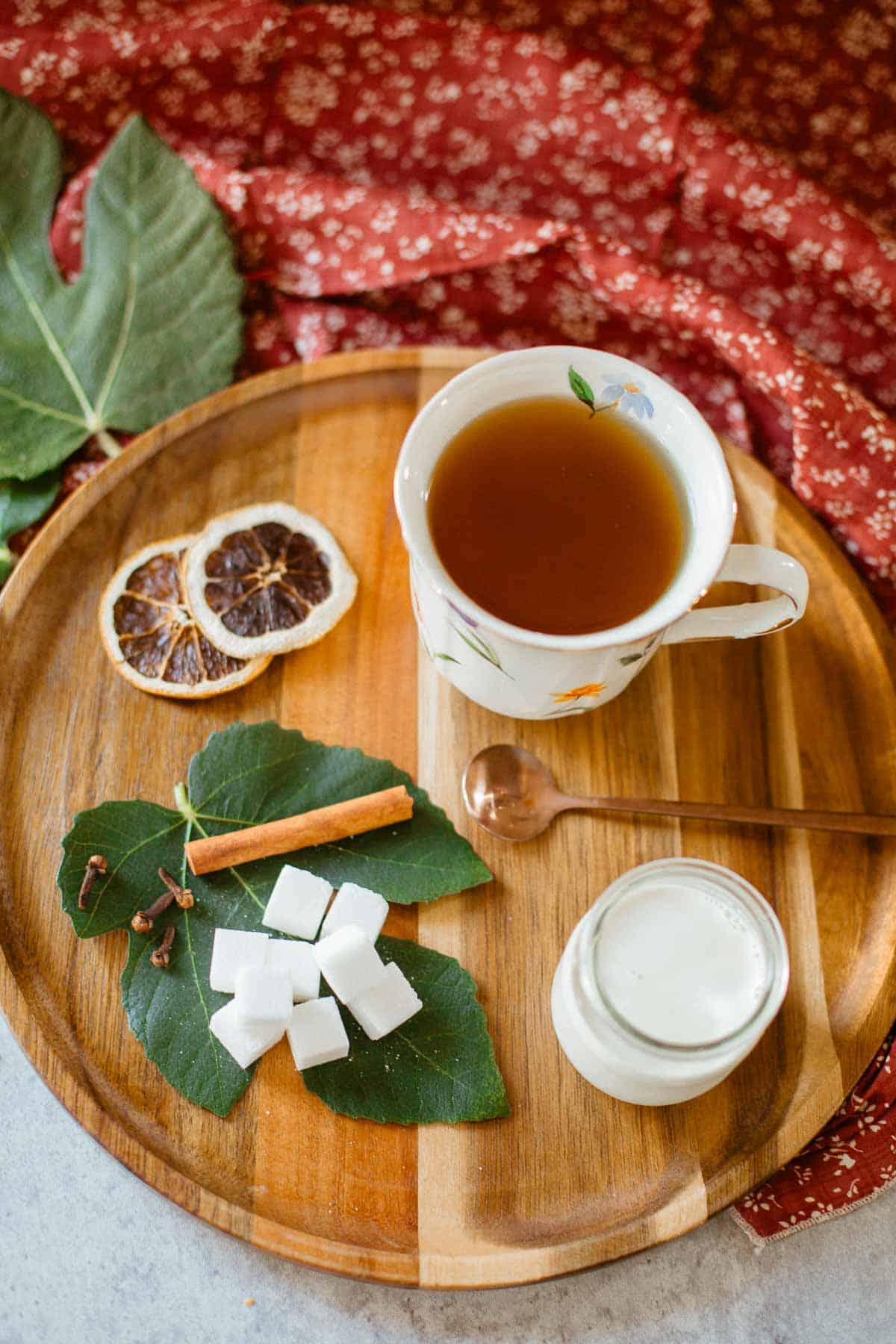 fig leaf tea on tray with fig leaves, aromatics, sugar, cream.