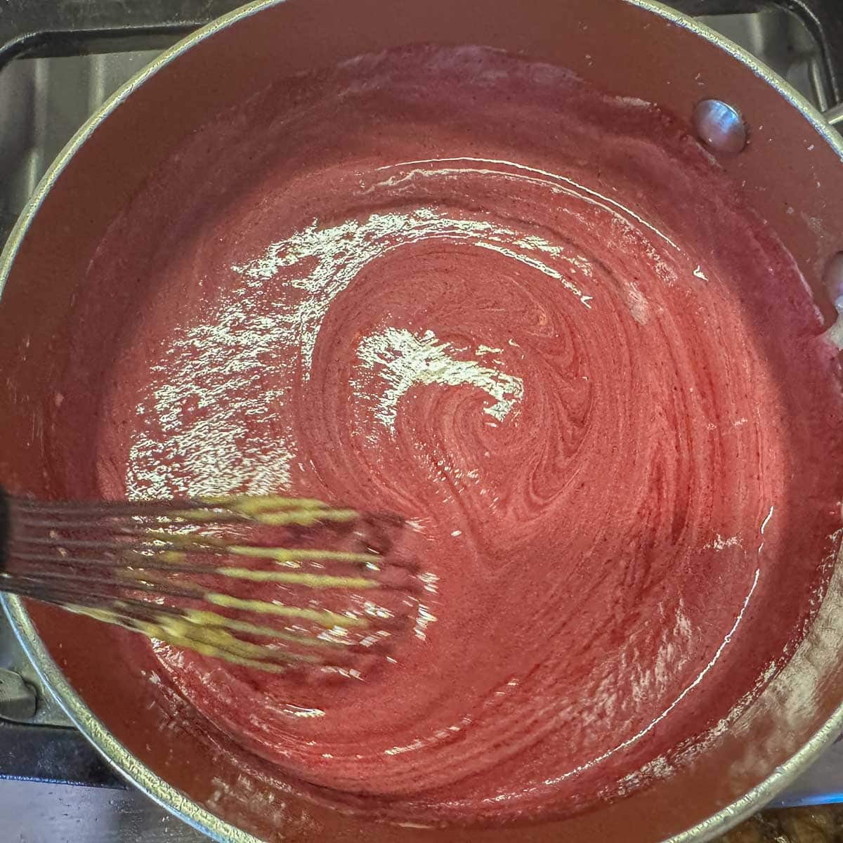 Swirling egg yolk mixture into huckleberry juice. 