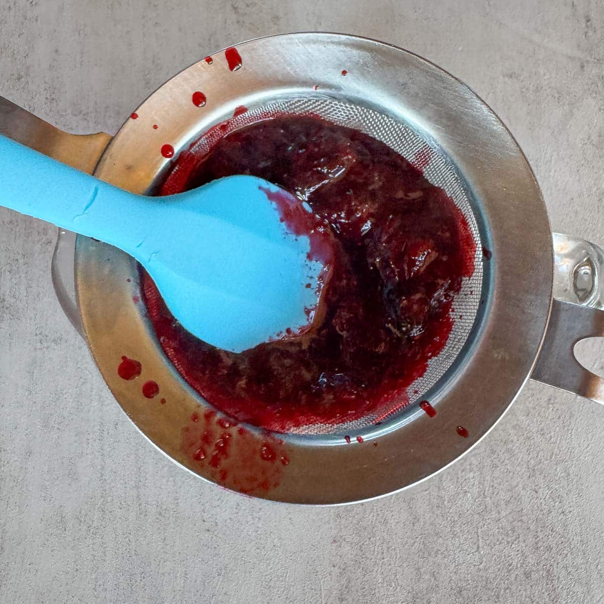Straining huckleberries in a  fine mesh sieve. 