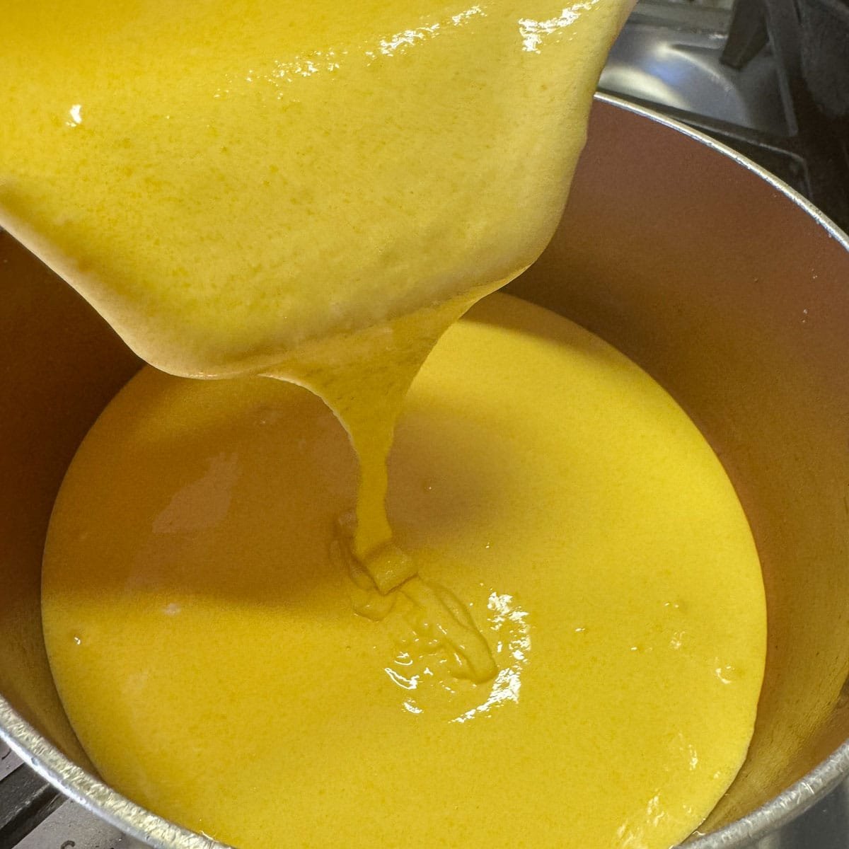 Pouring egg yolks into a pot. 