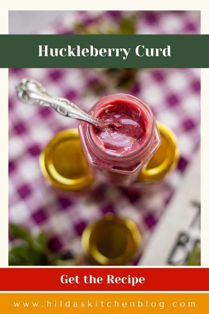 huckleberry curd jars with a spoon in the middle.