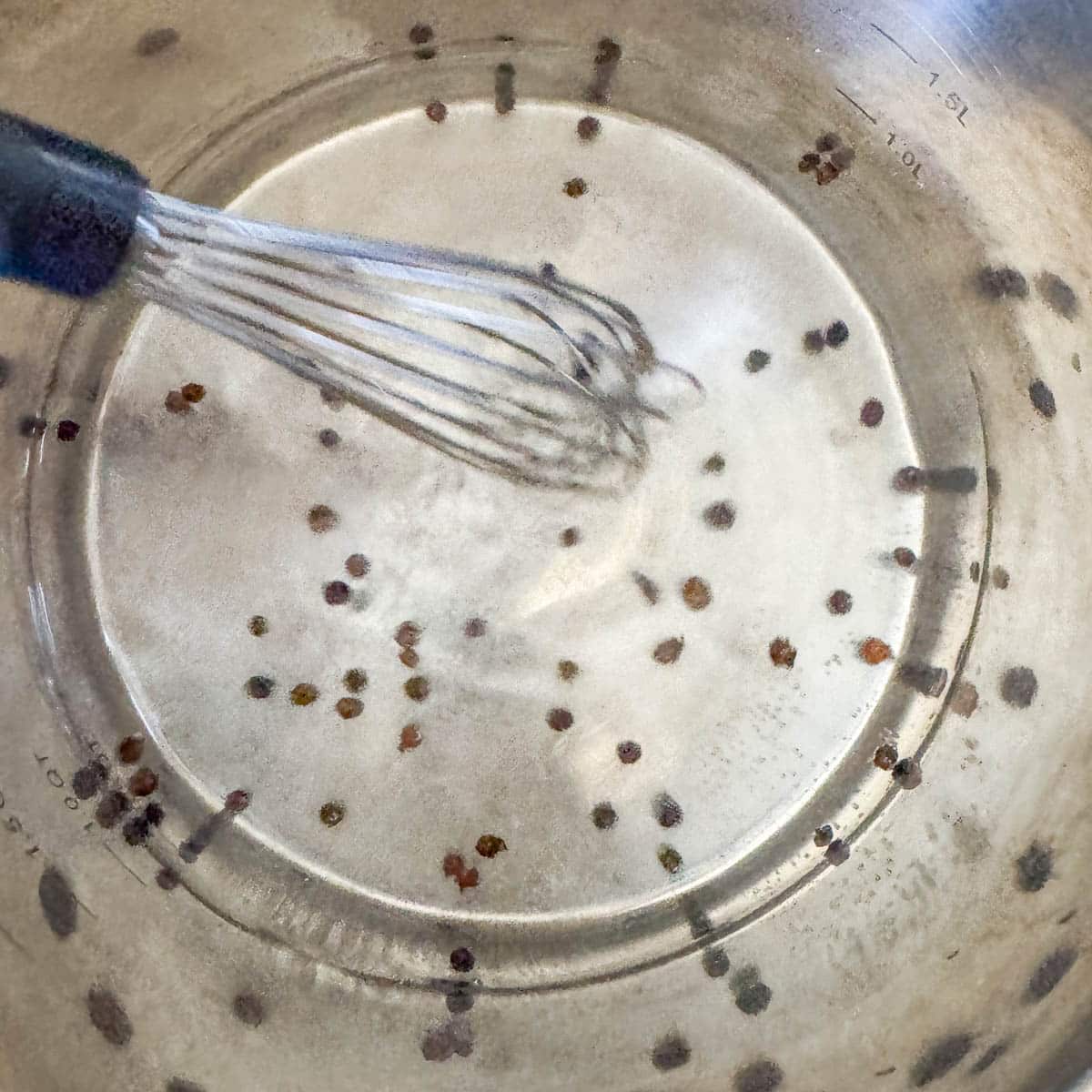 whisking brine ingredients in a pot. 