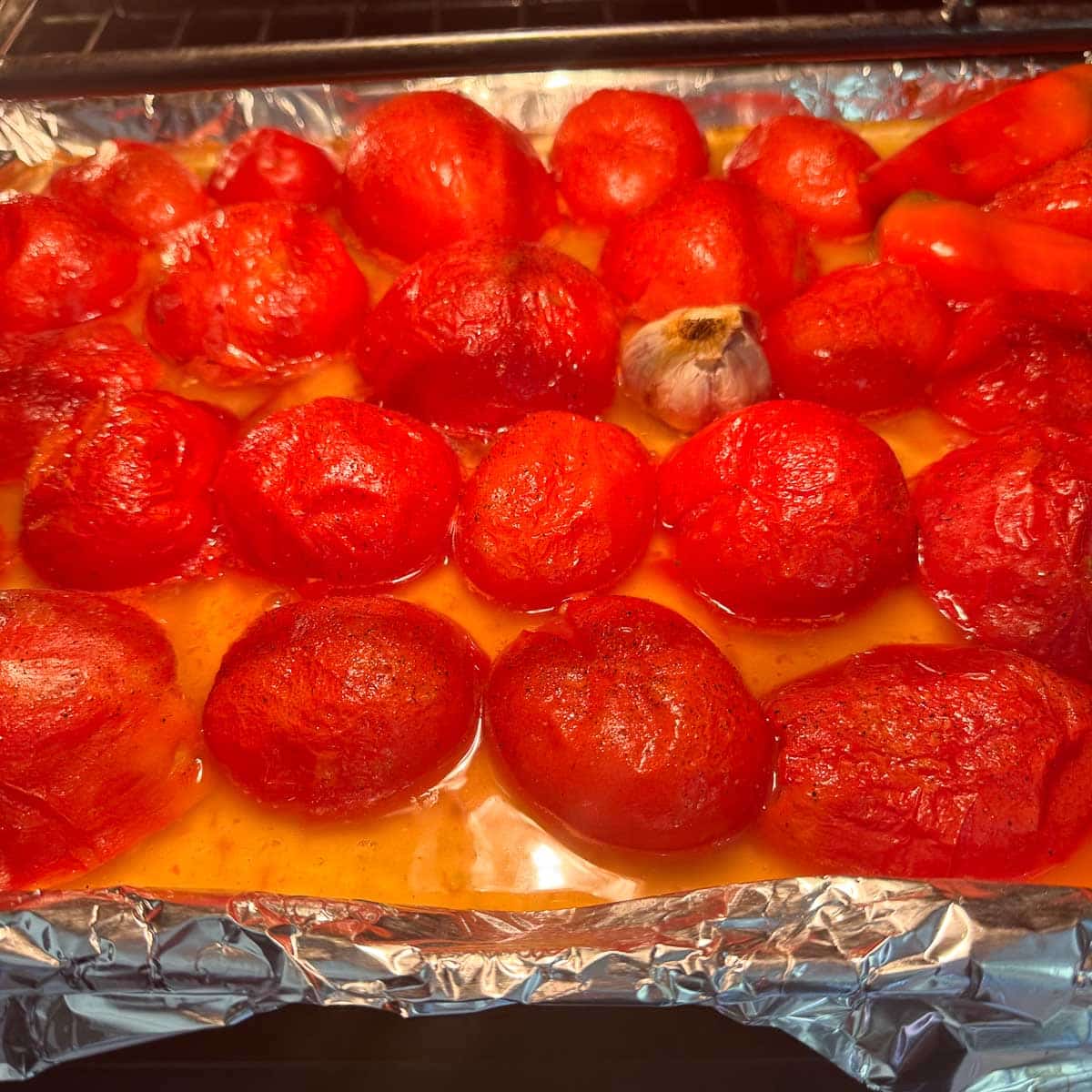 roasted tomatoes and garlic on a sheetpan.