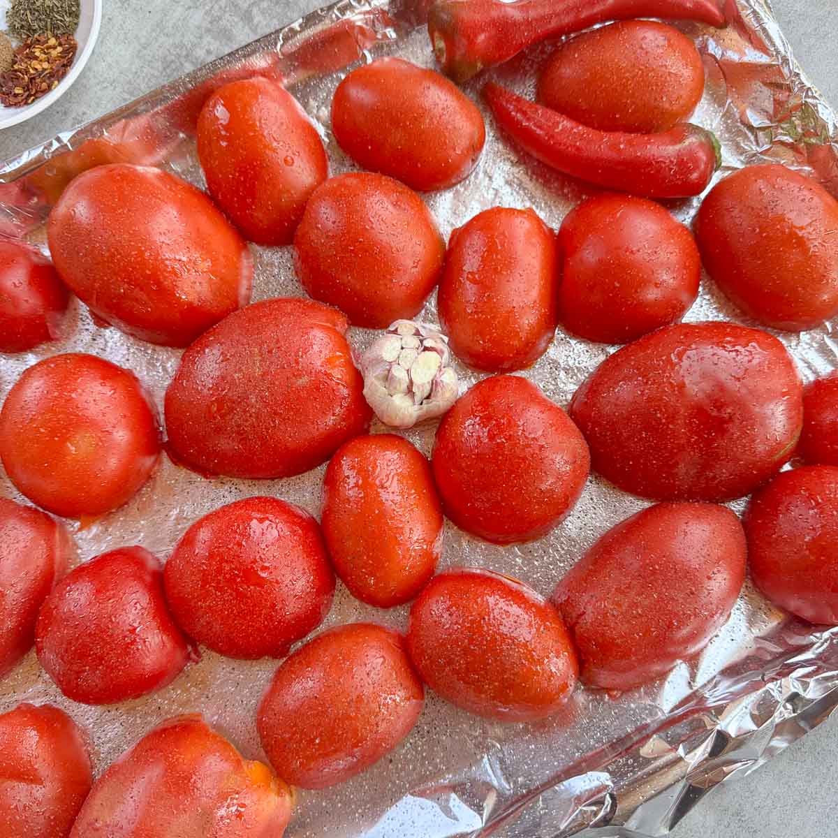 tomatoes and garlic on a foil lined pan.