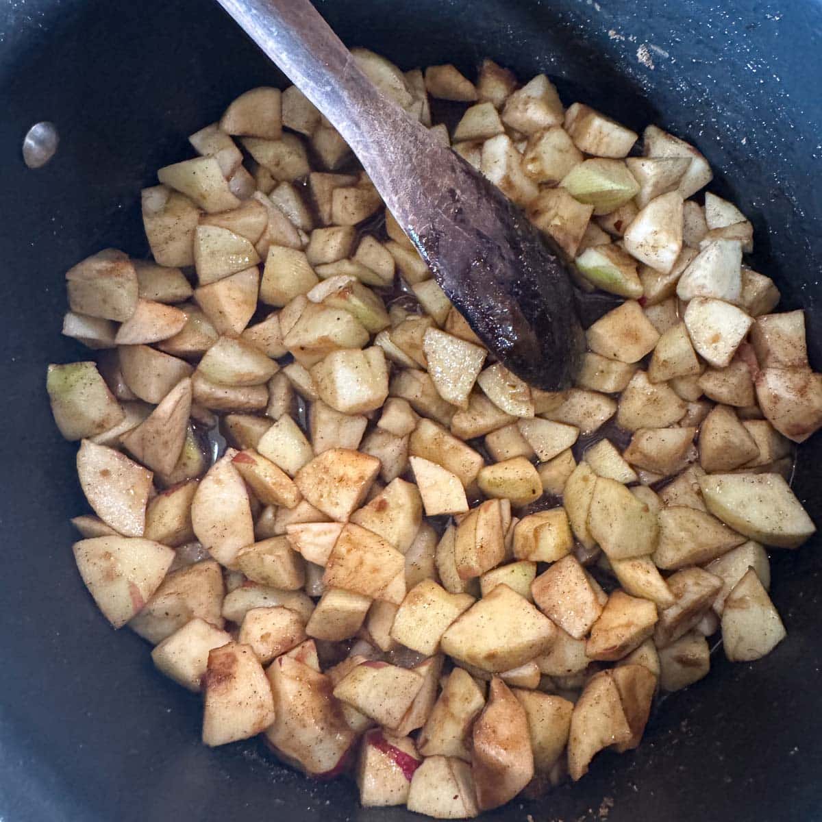 stirring chopped apples in a pot.