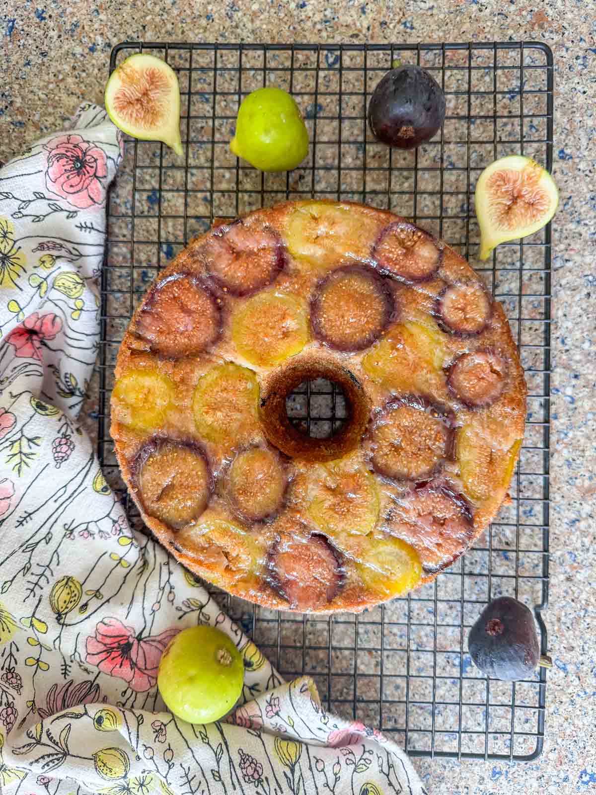 fig cake on a cooling rack with figs around it. 