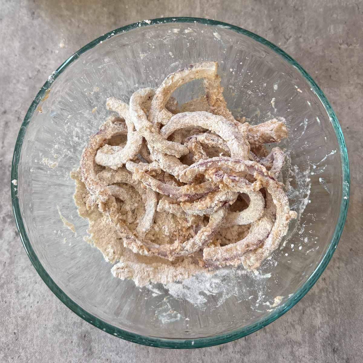 dredged onions in bowl of batter.