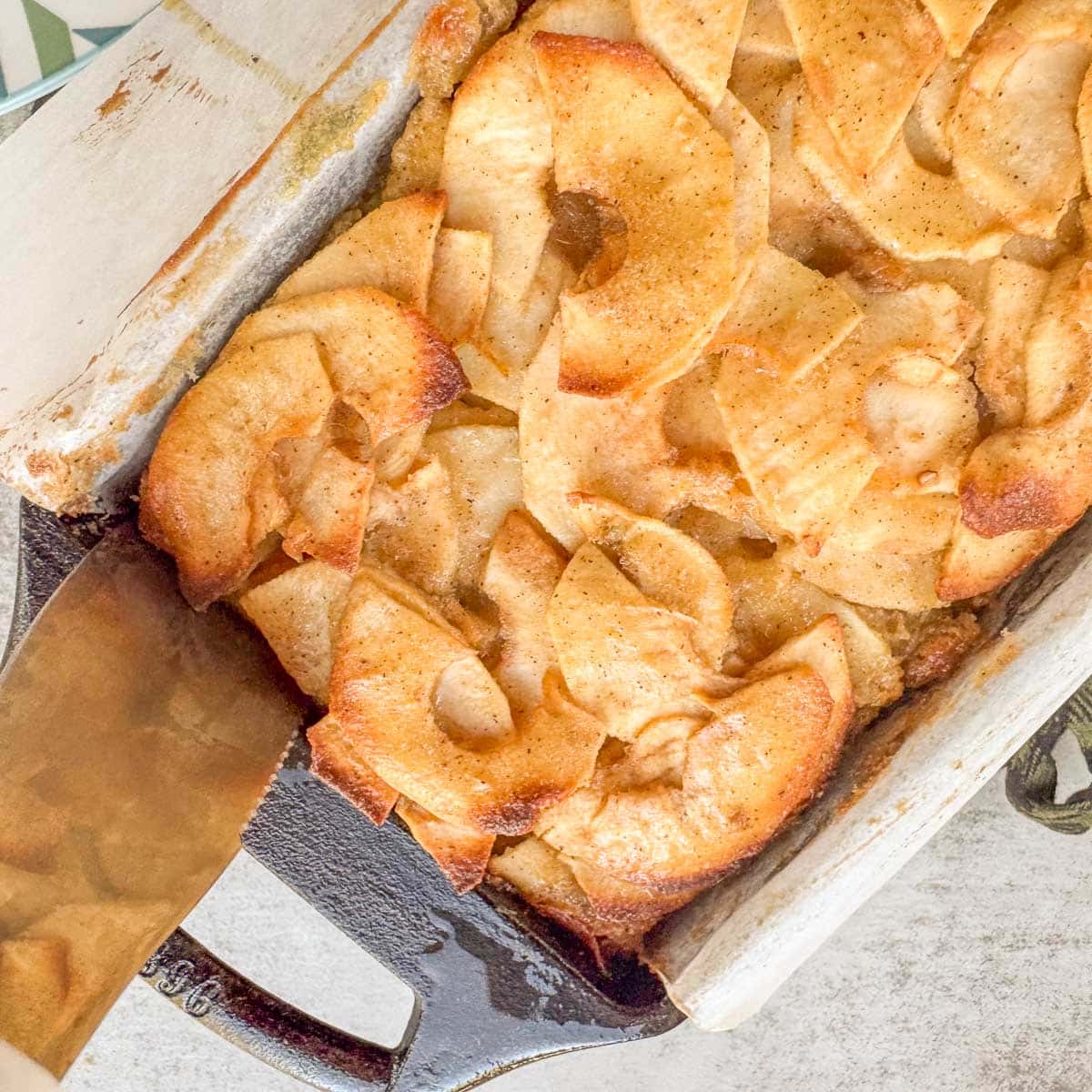 running a knife along the edge of an invisible apple cake in a loaf pan. 