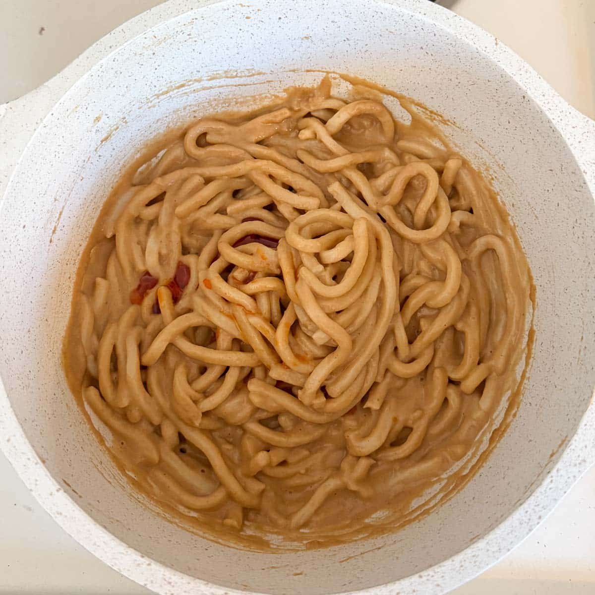 spicy peanut noodles in pot.
