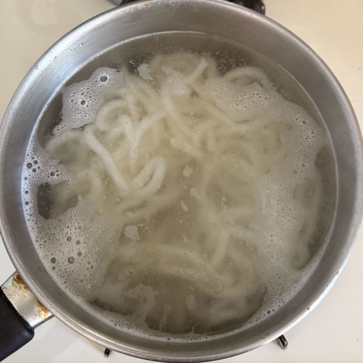 udon noodles boiling in pot.