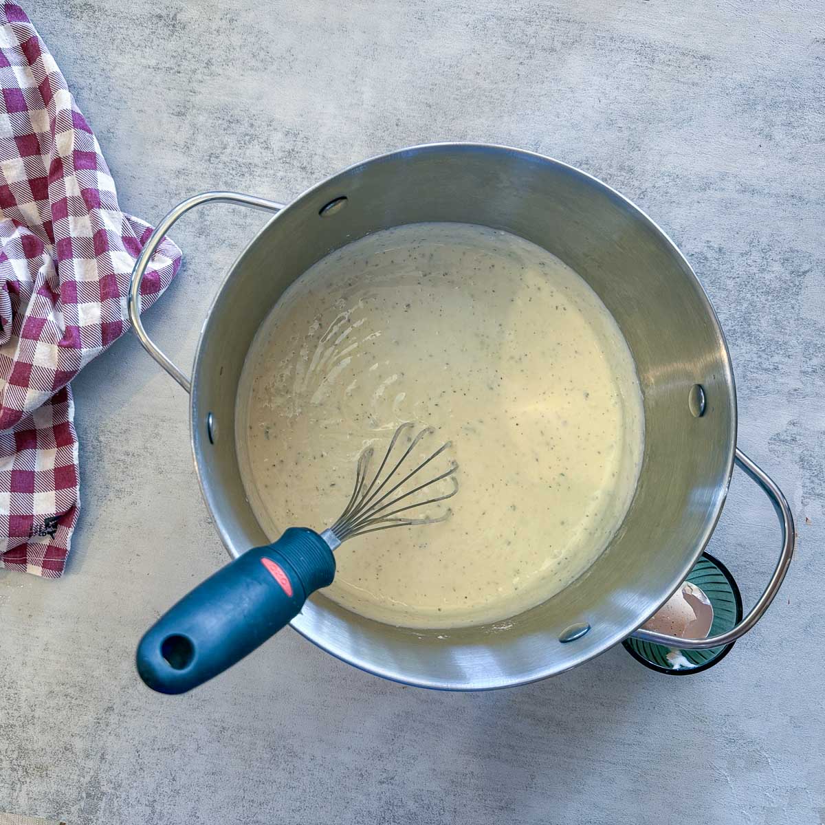 yogurt in a pot with a whisk. 