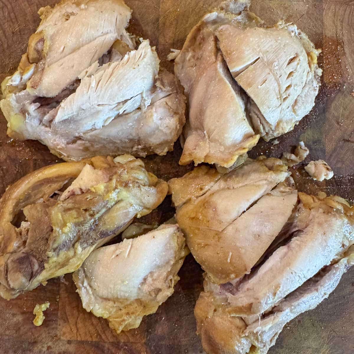 cooked chicken thighs on a cutting board.