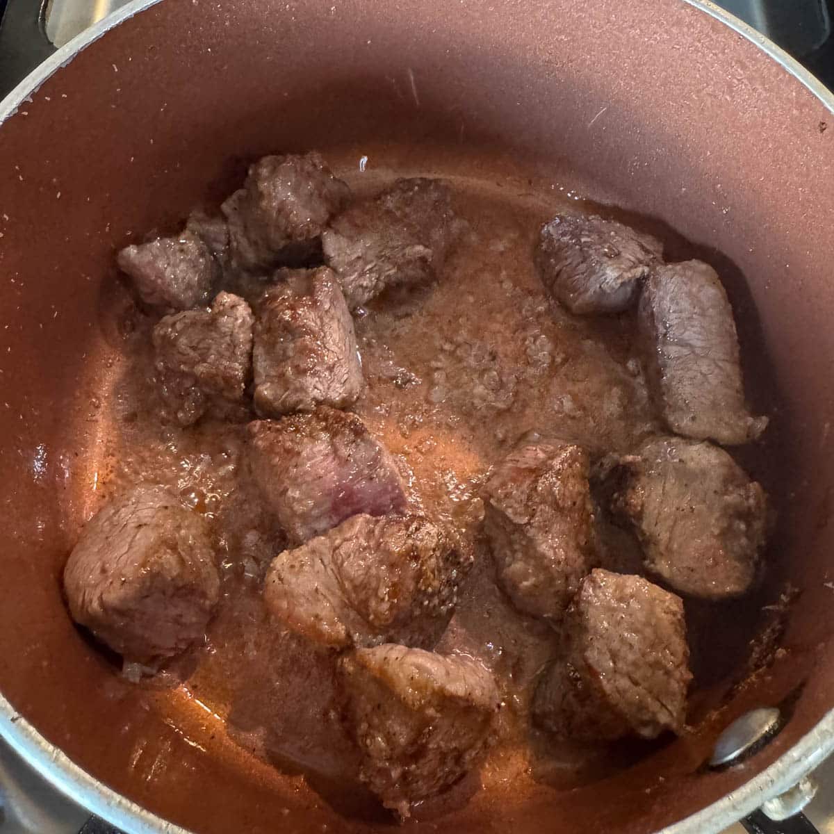 seared cubed meat in a pot. 