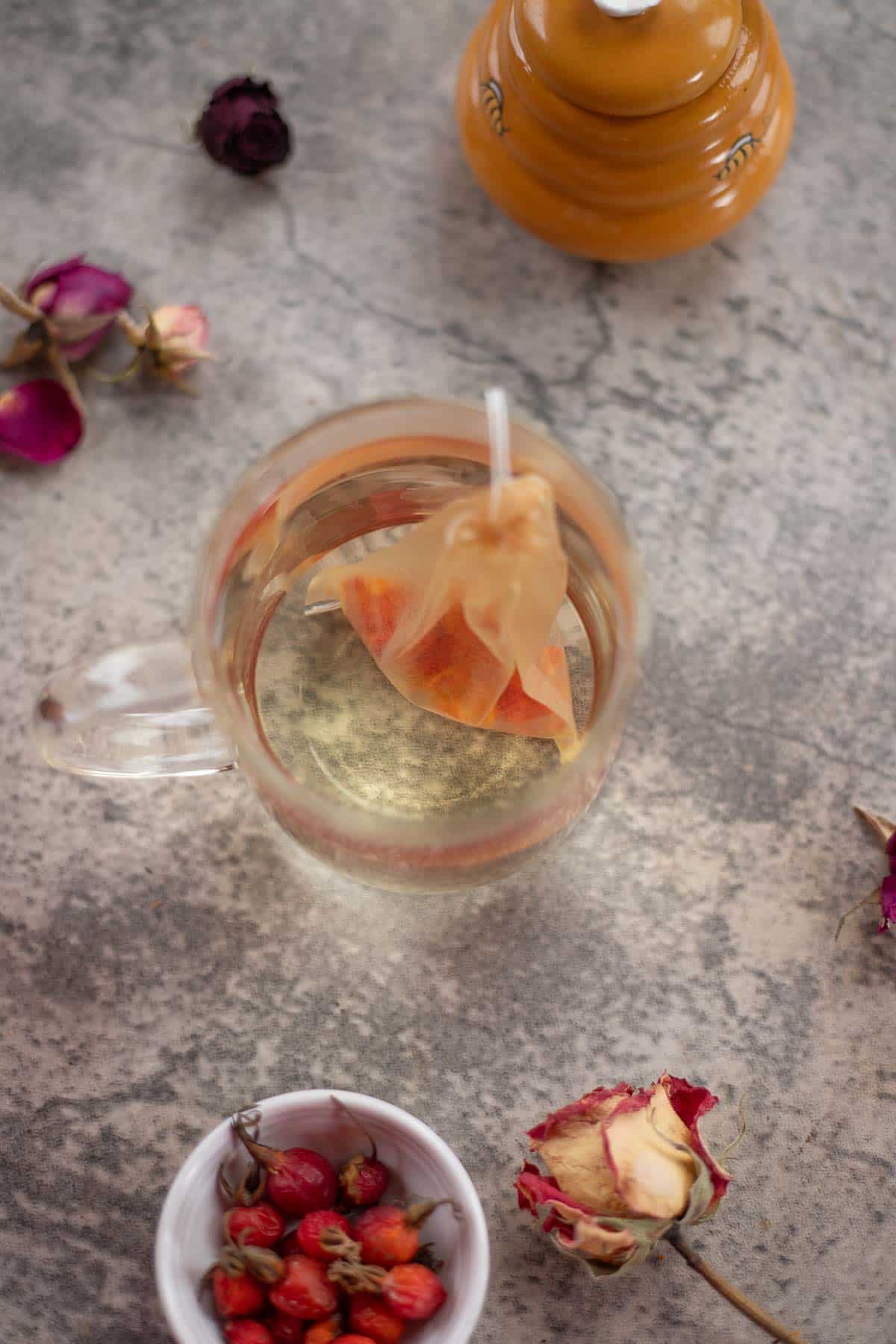 rosehip tea with dried roses around it. 