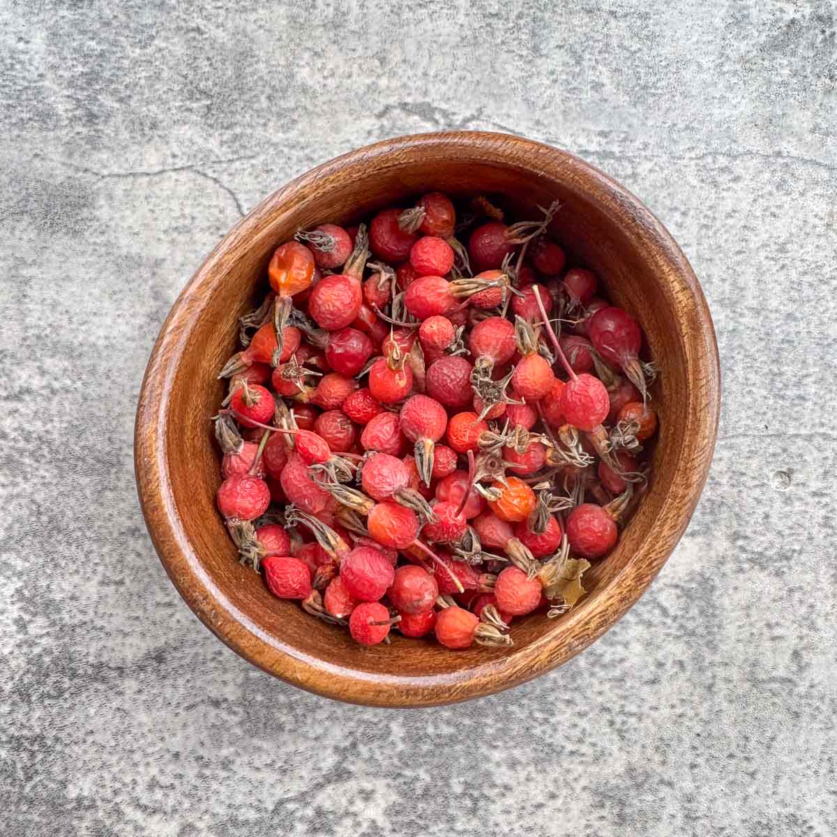 a wooden bowl with rosehips. 