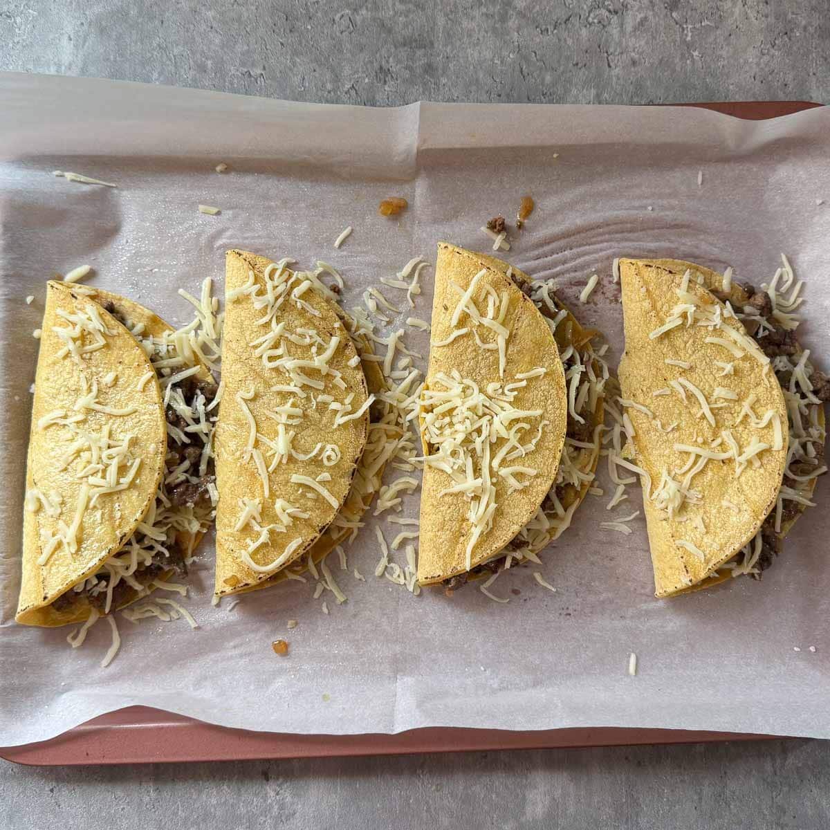 folded tacos on sheet pan before baking.