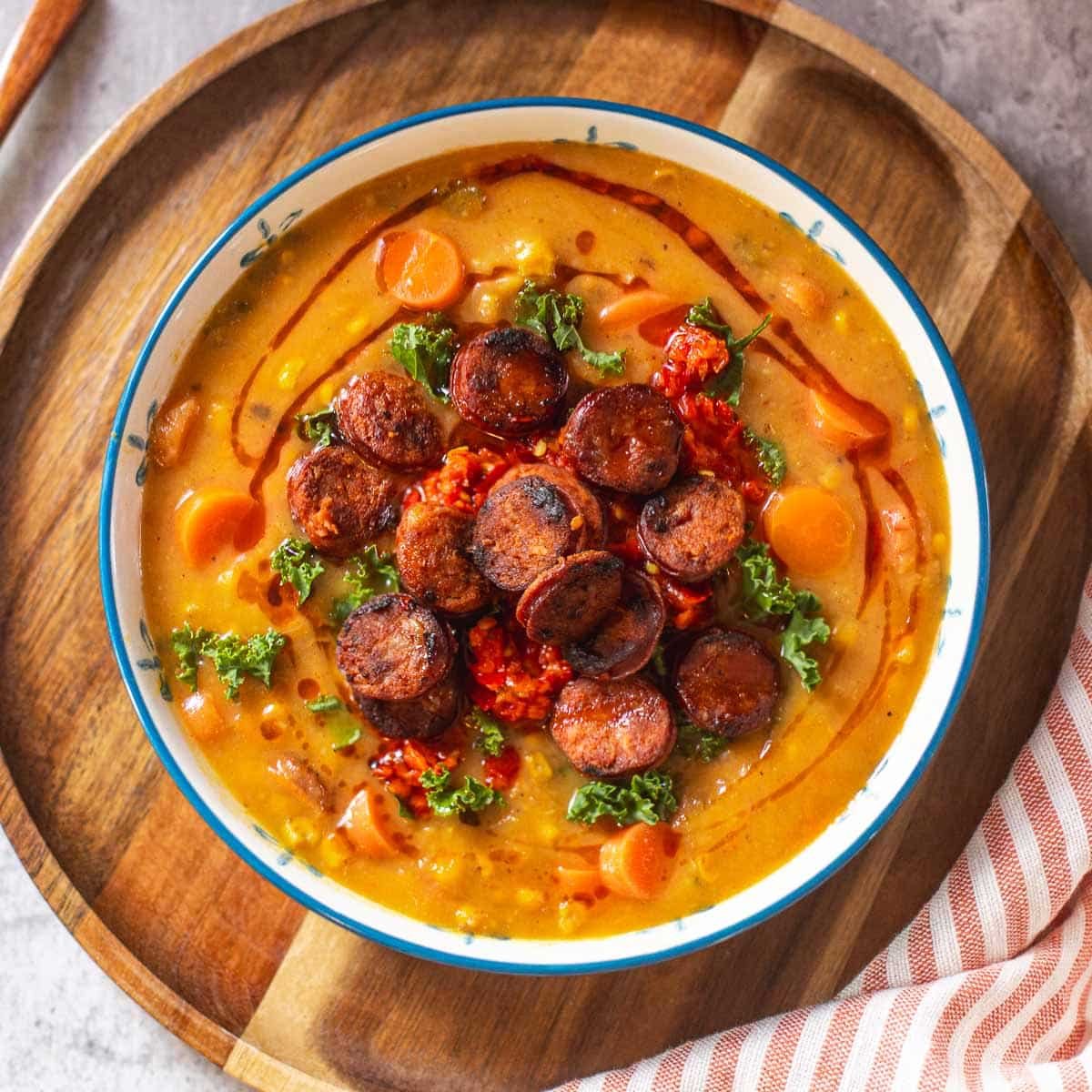chorizo soup in bowl beside hand towel.