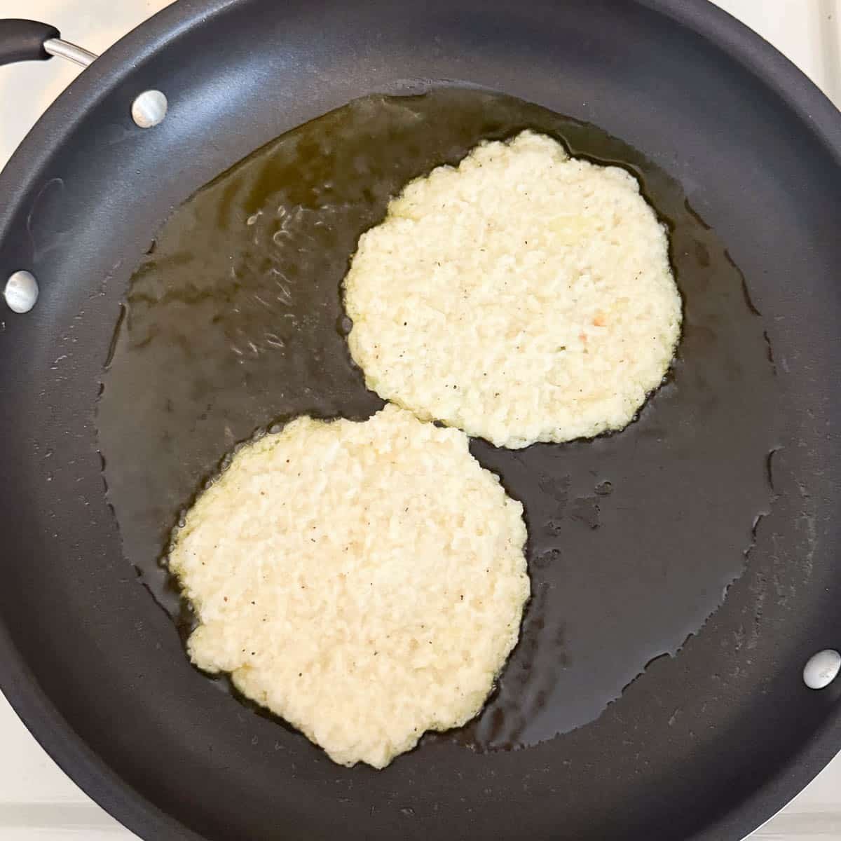 Deruny mixture frying in oil before flipping.