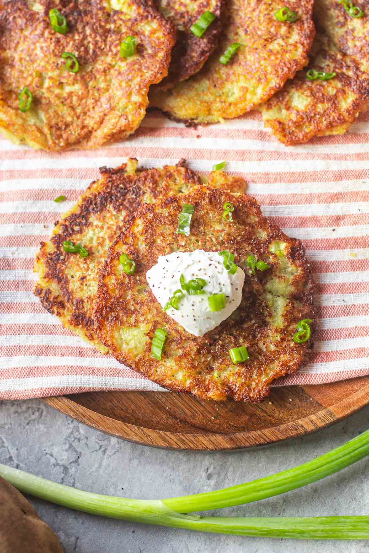 Deruny on striped mat topped with sour cream and green onions.